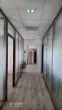 Grille de diffusion d’air intégrée au faux plafond d’un couloir de bureaux
